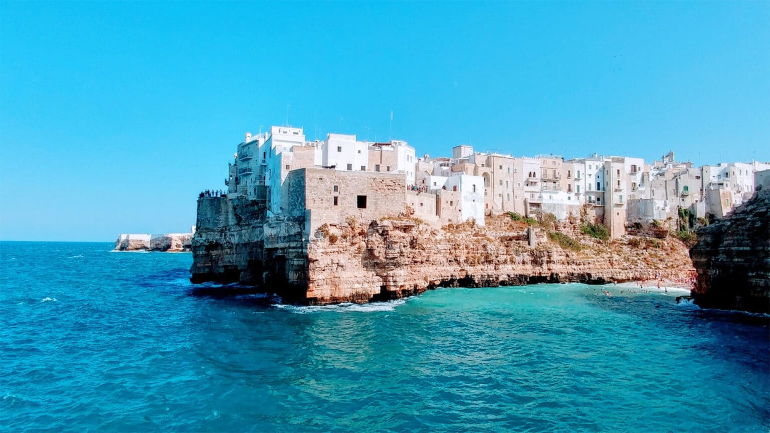 Scenic view of Polignano a Mare’s whitewashed buildings on cliffs above the Adriatic Sea.